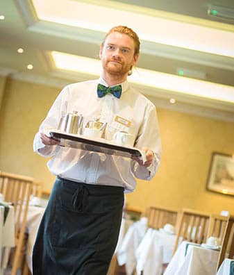 Waiter serving breakfast on a tray at one of our hotels