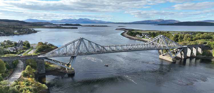 Connel Bridge, a historic railway bridge spanning the water, with its striking iron arch structure and scenic views of the surrounding landscape.