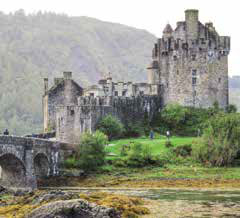 Eilean Donan Castle, an iconic Scottish castle, perched on a small island and surrounded by a scenic loch and rugged mountains.