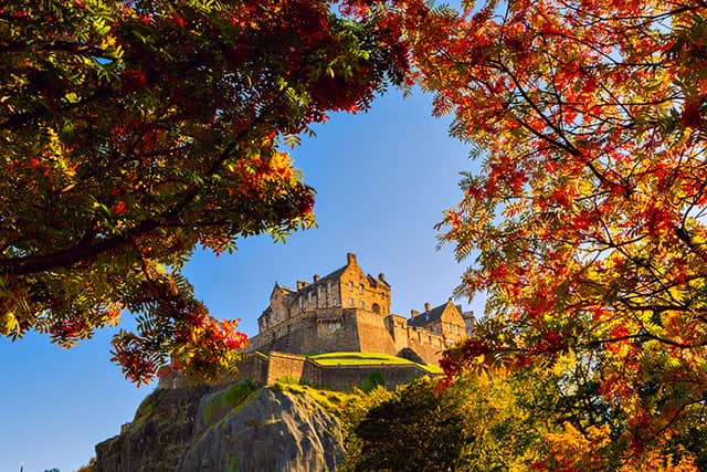 Edinburgh Castle framed by vibrant autumn leaves