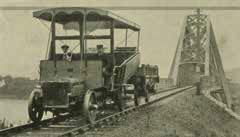 Vintage photograph of a railway car on the railway line, with an old bridge in the background, showcasing the historical transportation era.