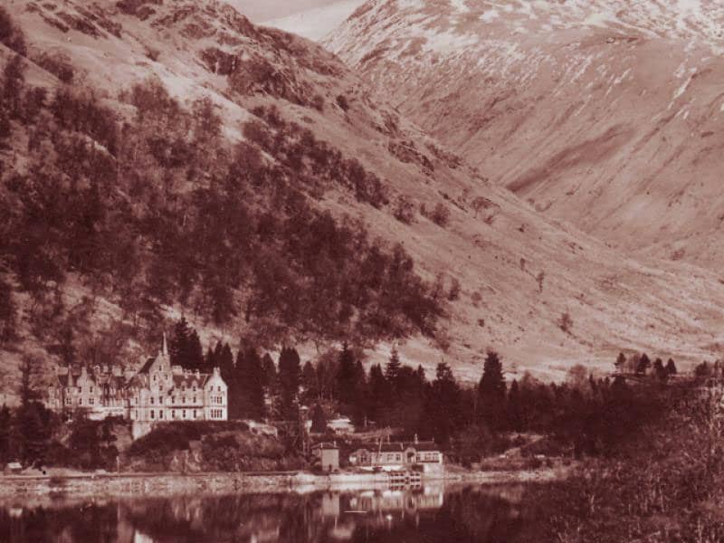 An old photograph of the Loch Awe Hotel with the grand mountains in background.