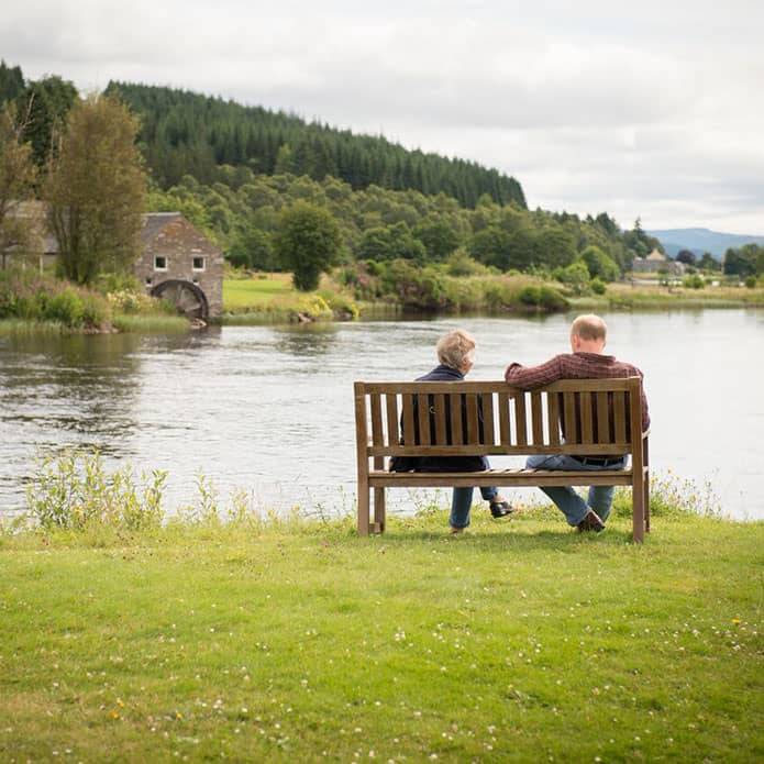 A customer sitting on a bench enjoying the scenery at the Loch Tummel Hotel